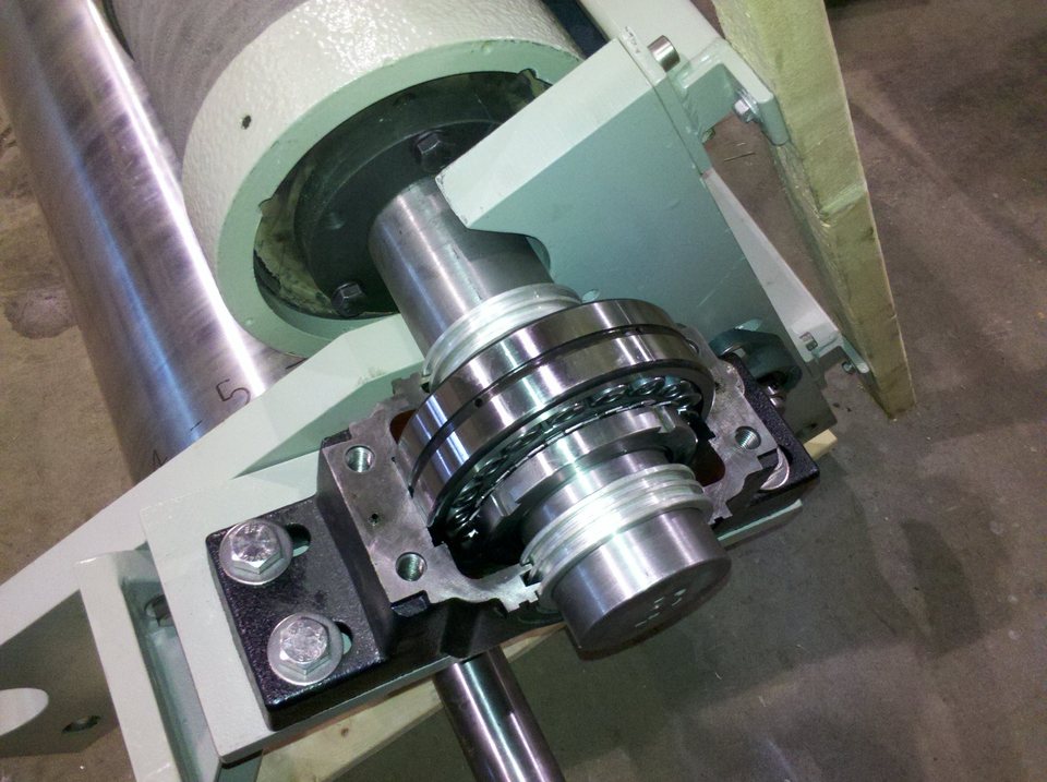 Partially assembled split pillow block without its top cap, showing a self-aligning ball bearing in the lower housing half and labyrinth seal rings on the shaft.